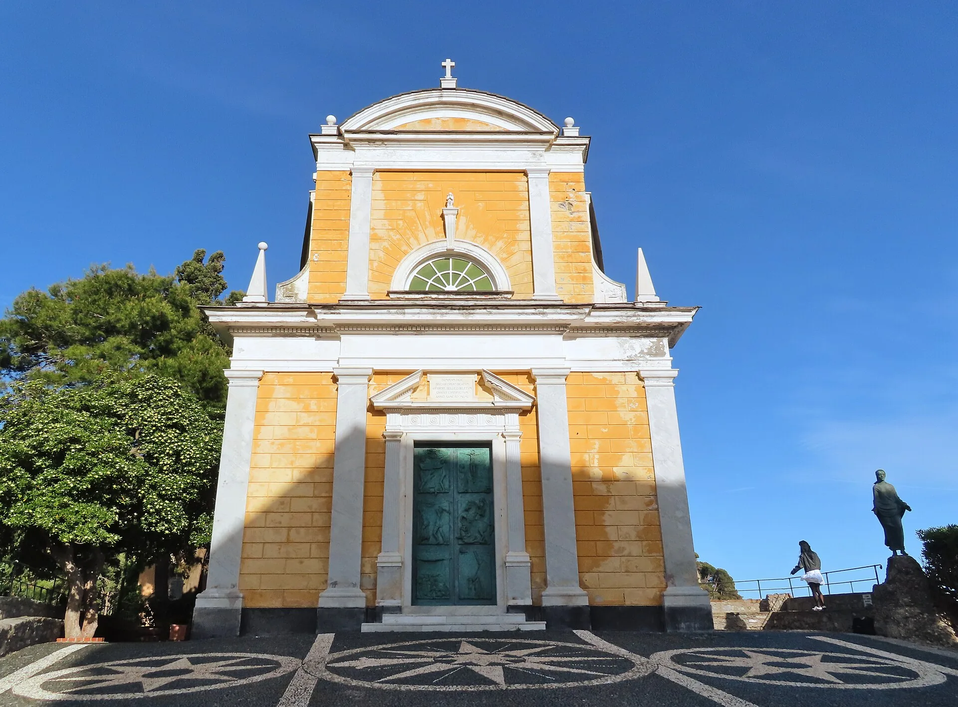 La facciata gialla della chiesa di San Giorgio a Portofino sotto il cielo azzurro