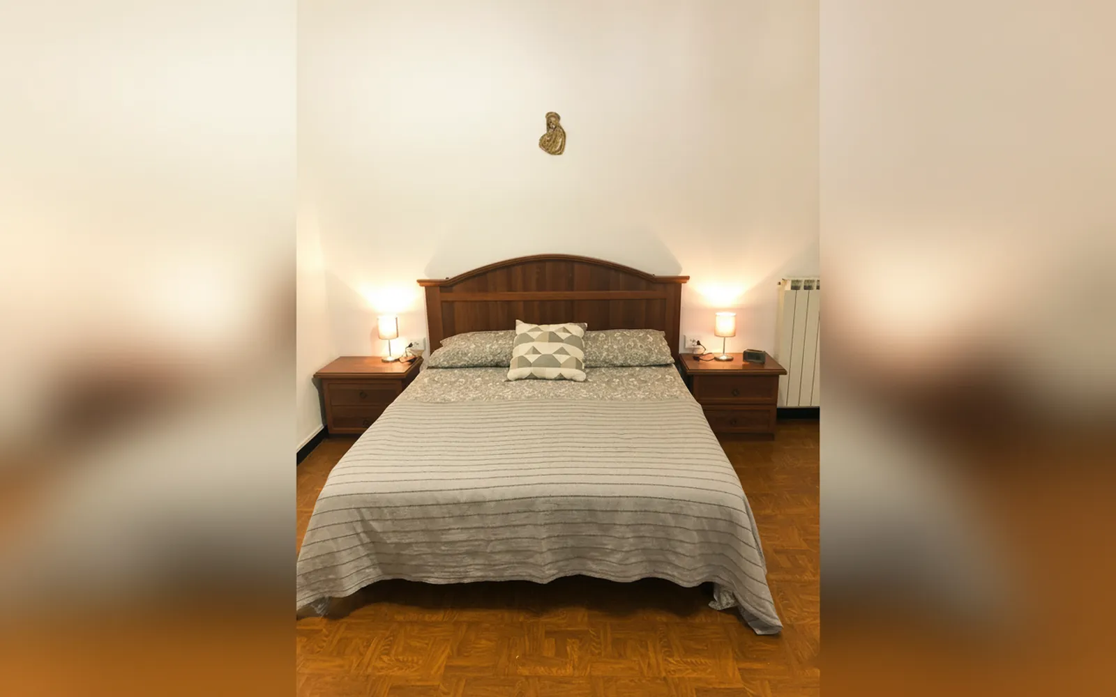 Una camera matrimoniale con testiera in legno e abat-jour